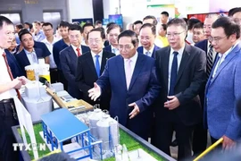 越南总理范明政参观科技应用产品展位。图自越通社