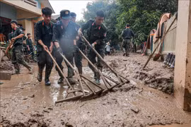 战士们为老街省保安县福庆乡人民清理泥土。图自越通社