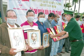 朔庄省边防部队向渔民赠送国旗和胡志明主席肖像