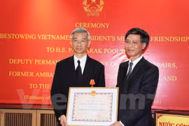 越南驻泰国大使​阮必成向泰国外交部副常任秘书、前泰国驻越大使潘雅拉克​授予越南国家主席的友谊勋章 （图片来源：越通社）