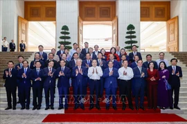 越南政府总理范明政（右六）和国会主席陈青敏（右七）与政府成员合影。图自越通社