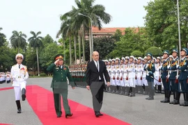 越南国防部长吴春历大将同法国国防部长让·伊夫·勒德里昂检阅仪仗队。（图片来源：越通社）