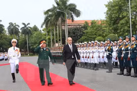 越南国防部长吴春历大将同法国国防部长让·伊夫·勒德里昂检阅仪仗队。（图片来源：越通社）