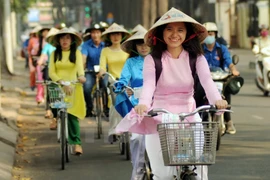 数百名女生参加“长衣之城——我爱的城市”自行车游行活动（图片来源：越通社）