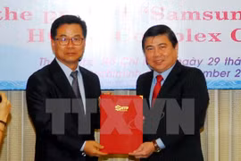 胡志明市人民委员胡主席阮城锋颁发了胡志明市三星家用电子综合园区（SEHC）项目调整投资额的投资许可证（图片来源：越通社）