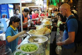 外国游客品尝越南美食。