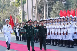 越南国防部部长潘文江大将与老挝国防部部长坎良·奥萨宋上将检阅仪仗队。图自越通社
