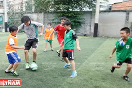 Kitaguchi Haruki与儿童踢足球。