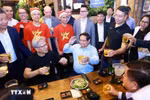 2024年12月5日晚，越南政府总理范明政与NVIDIA公司创始人兼首席执行官黄仁勋一起享用河内街头美食。图自越通社