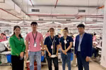 越南驻马来西亚大使馆一等秘书、劳工和专家管理事务负责人黎玉全（右一）、大使馆一等秘书蔡氏香（左一）在马来西亚柔佛州Ramatex纺织厂与越南工人合影。图自越通社