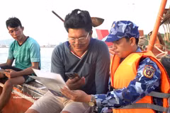 第四海警区官兵向渔船船员宣传打击非法、不报告、不受管制捕捞行为。图自越通社