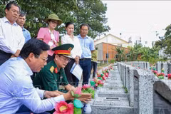 西宁省人民委员会副主席范晋和（左一）与工作团在安静烈士陵园（西宁省安静坊）核查未确定身份烈士墓的信息。图自越通社 