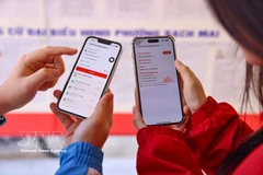 河内理工大学的学生选民在VNeID应用上查看候选人信息，以便主动了解情况，在参与选举时提高认识。图自越通社