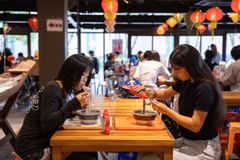 神田外语大学学生品尝越南河粉。图自越通社 