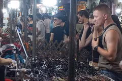 国际游客在河内古街夜市选购纪念品。图自越通社