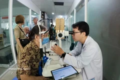 西贡眼科医院的医生为胡志明市春和坊的居民进行诊疗。图自越通社