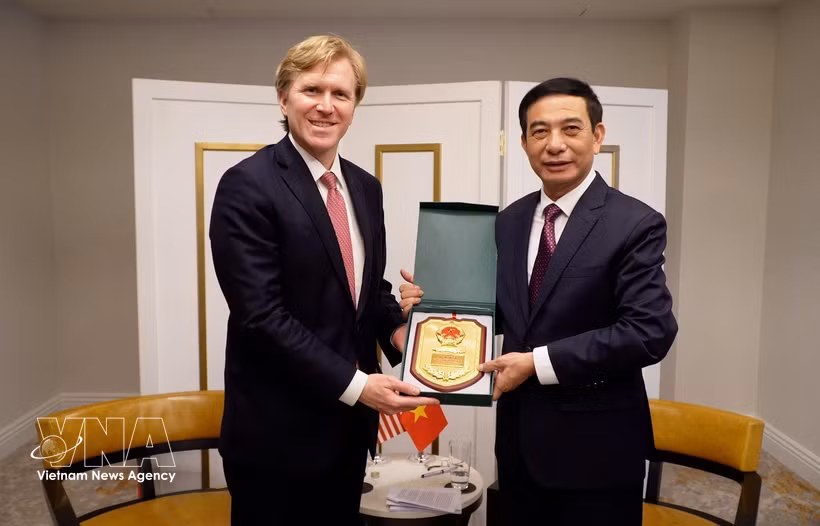 越南国防部部长潘文江向美国战争部第一副部长科尔比赠送礼品。图片来源：越通社