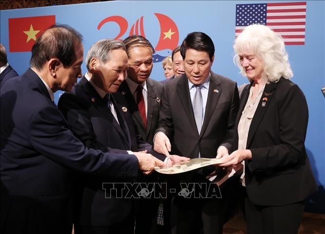 国家主席梁强与越美两国老兵及老兵家属一同观看战争遗物与资料。图自越通社