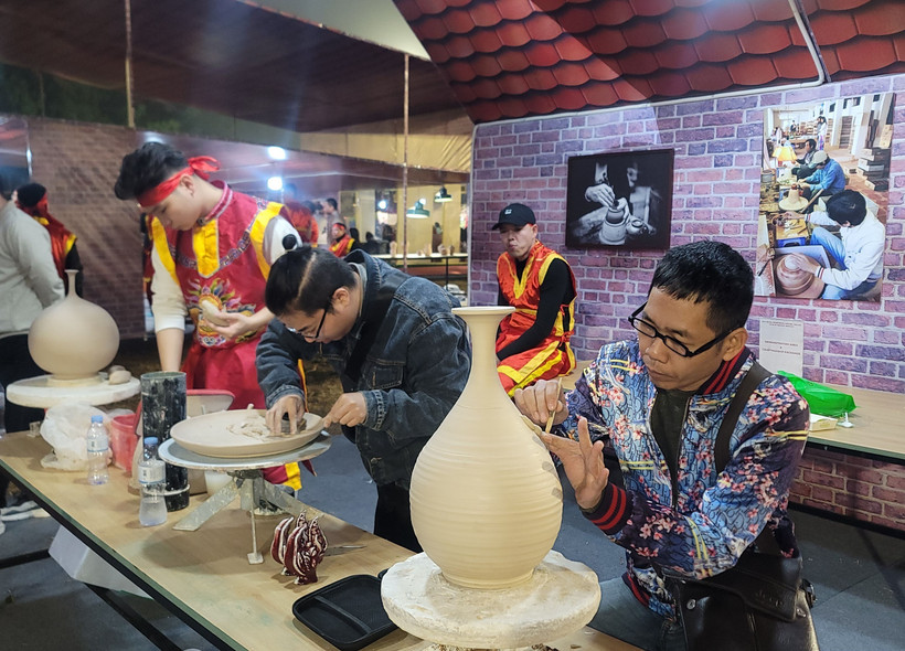 钵场陶瓷村陶瓷工艺师在钵场陶瓷村和万福丝织村加入全球创意城市网络“手工艺之都”证书授予仪式暨2025年河内手工艺品展示、演示与创作活动上介绍其村产品。