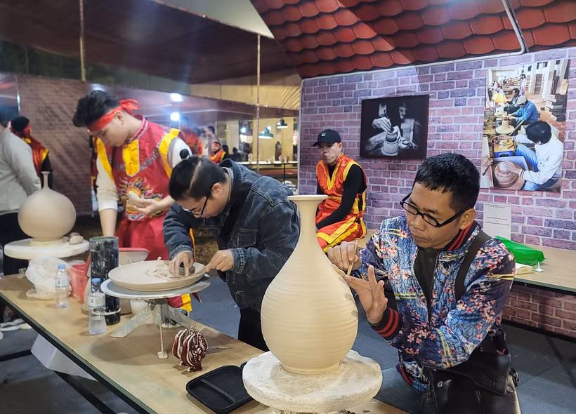 钵场陶瓷村陶瓷工艺师在钵场陶瓷村和万福丝织村加入全球创意城市网络“手工艺之都”证书授予仪式暨2025年河内手工艺品展示、演示与创作活动上介绍其村产品。