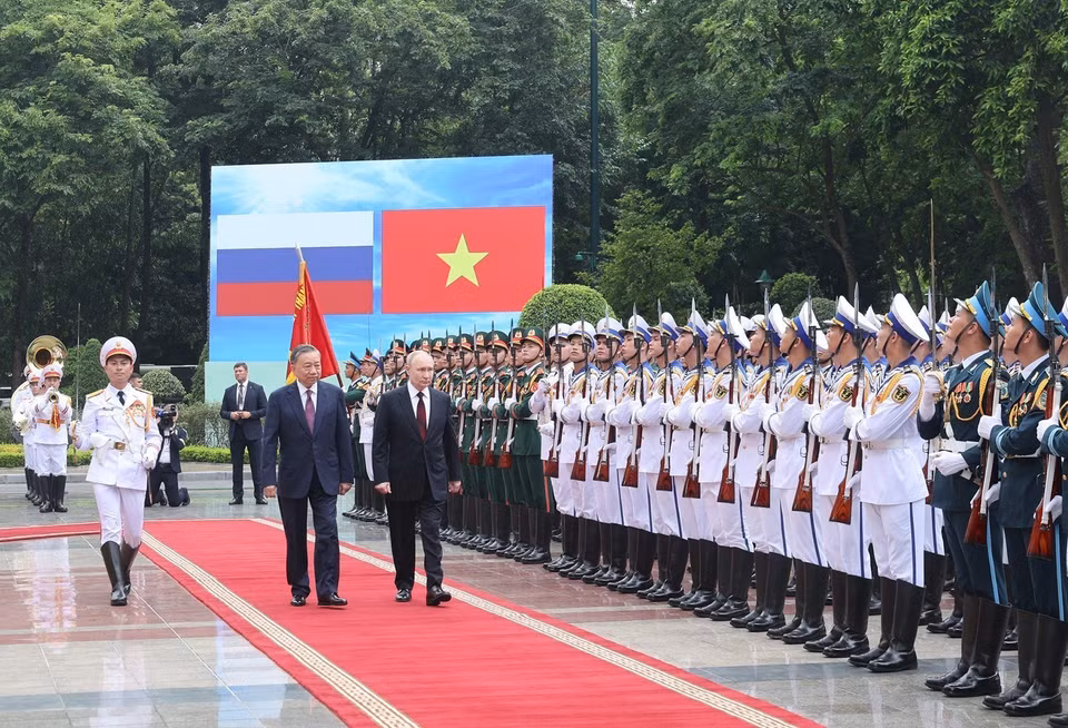 在军乐团的雄壮演奏声中，越南国家主席苏林和俄罗斯联邦总统弗拉基米尔·普京检阅越南人民军仪仗队。图自越通社