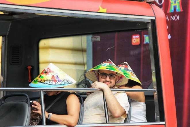 外国游客参观河内古街。图自越通社 Du khách nước ngoài trải nghiệm tham quan phố cổ Hà Nội trên xe điện.(TTXVN).webp