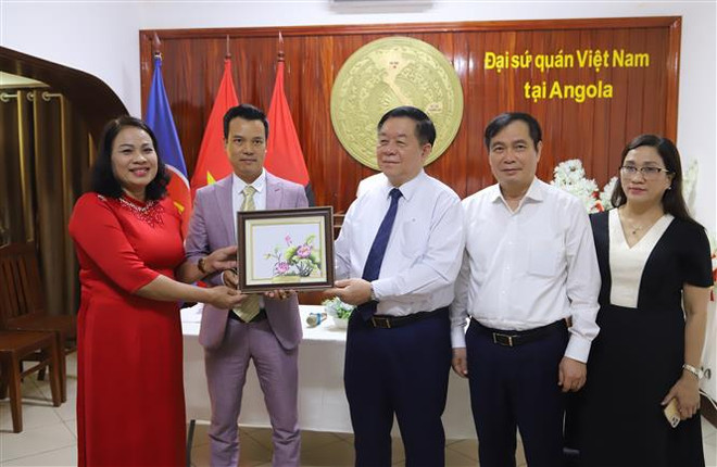 阮仲义向在安哥拉越南人社群代表赠送纪念品。图自越通社 Trưởng ban Tuyên giáo Trung ương Nguyễn Trọng Nghĩa tặng quà lưu niệm cho đại diện cộng đồng người Việt Nam tại Angola. Ảnh TTXVN.jpg