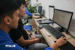 志愿团员指导群众在线申报为子女办理出生证明。图自越通社