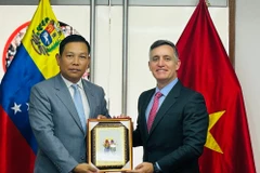 越南驻委内瑞拉大使武中美向卡尔迪略部长送上纪念品。图自越通社