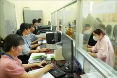 胡志明市泰美乡干部、公务员为群众办理行政手续。图自越通社