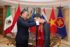 马来西亚驻墨西哥大使贾马尔·乔翰向越南驻墨西哥大使阮文海移交象征东盟驻墨西哥委员会(ACMC)主席职务的绶带。图自越通社