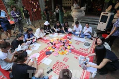 游客和儿童可亲身体验制作五角星灯笼、走马灯、纸博士、竹蜻蜓等传统手工艺。图自越通社