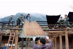 莱州省公安厅干部、战士与当地群众携手协作积极推进拆除临时房、危旧房的工作。图自越通社