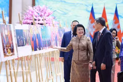 越南政府总理黎明兴与柬埔寨王国国会主席昆索达莉亲王参观由越南通讯社举办的关于两国合作关系的图片展。图自越通社