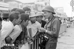 越通社记者许检在西贡会见群众，报道并拍摄1975年历史性胡志明战役的胜利，完全解放南方，实现国家统一。图自越通社