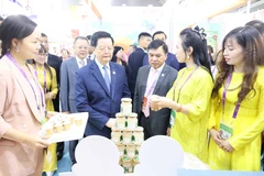 越南政府副总理梅文政参观越南企业的展位。图自越通社