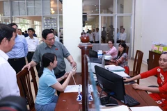越南政府总理范明政前往芹苴市宁桥坊公共行政服务中心视察工作。图自越通社