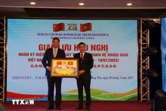 巴地头顿省越中友好协会会长黄文名向中国驻胡志明市总领事魏华祥送上纪念品。图自越通社