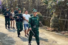 老街国际口岸边防部队押解“LC326”专案2名涉嫌贩运人口犯罪嫌疑人。图片来源：越通社