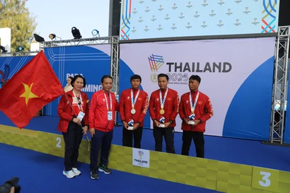 越南文化、体育与旅游部副部长黄道刚与代表团团长黎氏黄燕同夺得金银铜奖牌的3名运动员合影留念。图片来源：越通社