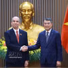 越南政府总理黎明兴与古巴共和国驻越南特命全权大使罗赫略·波兰科·富恩特斯亲切握手。图自越通社