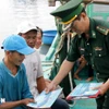 向渔民发放有关打击IUU捕捞的宣传资料。图自越通社。