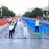医务人员与民众同演健身操，向社区传递健康生活理念。图自越通社
