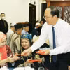 胡志明市领导向少数民族代表赠送新年红包。图自越通社
