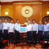 建设部领导向越南祖国阵线中央委员会主席杜文战移交捐款。图自越南妇女报