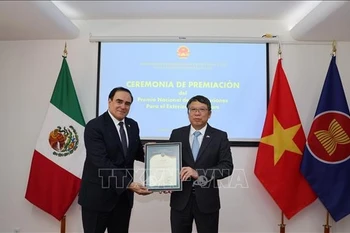 越南驻墨西哥大使阮文海向穆里斯·萨卢姆·乔治先生颁发奖状。图自越通社