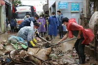  武装力量将村庄、居民区道路上的淤泥清除干净。图自越通社