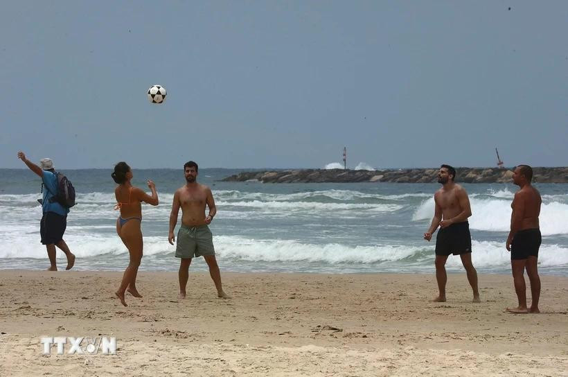 6月24日，以色列-伊朗停火协议正式生效后，当地居民在以色列特拉维夫的海滩上进行体育运动。图自越通社