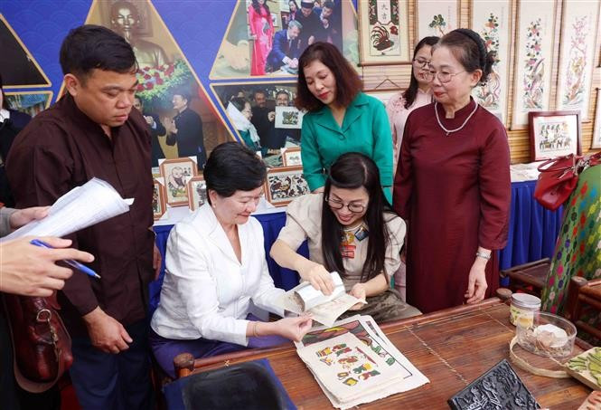 越南政府总理夫人同河内市东盟妇女小组体验东湖民间画印制。图自越通社