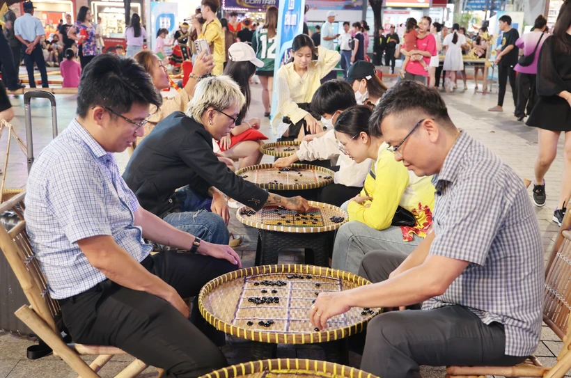 游客体验民间游戏。图自越通社